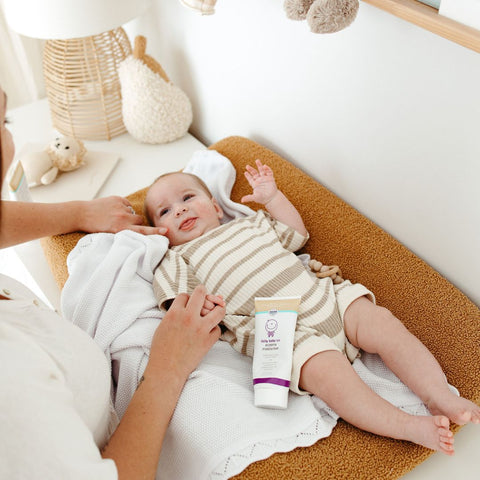Mother applying natural moisturiser to baby’s sensitive skin after bath time